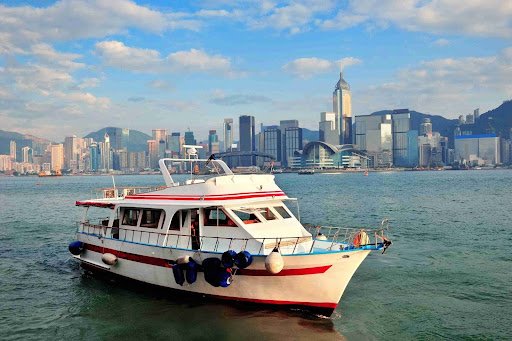 Image of a white ferry boat docked at a pier, ready to load passengers
