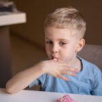 Young child self-soothing with fingers, a common early habit linked to thumb-sucking behavior.
