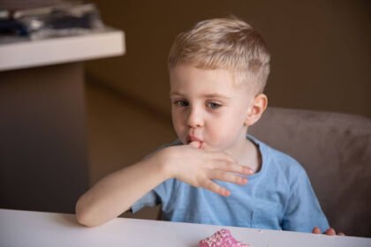 Young child self-soothing with fingers, a common early habit linked to thumb-sucking behavior.